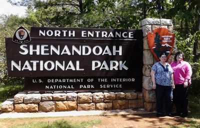 Women in front of Shenandoah National Park sign.