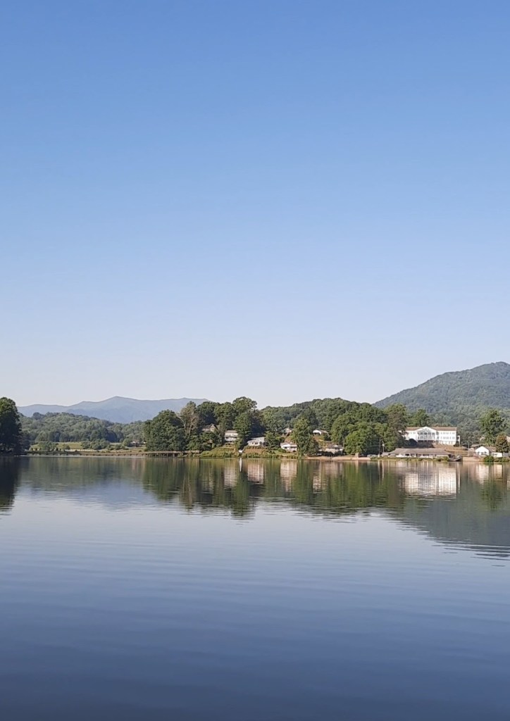 Lake Junaluska North Carolina: Lake with houses in the distance. Mountains behind that. Summer sky.