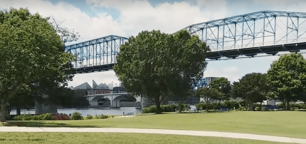 Park in Chattanooga, Tennessee. Pedestrian bridge, trees, green grass. Taken across the river from the Tennessee Aquarium.