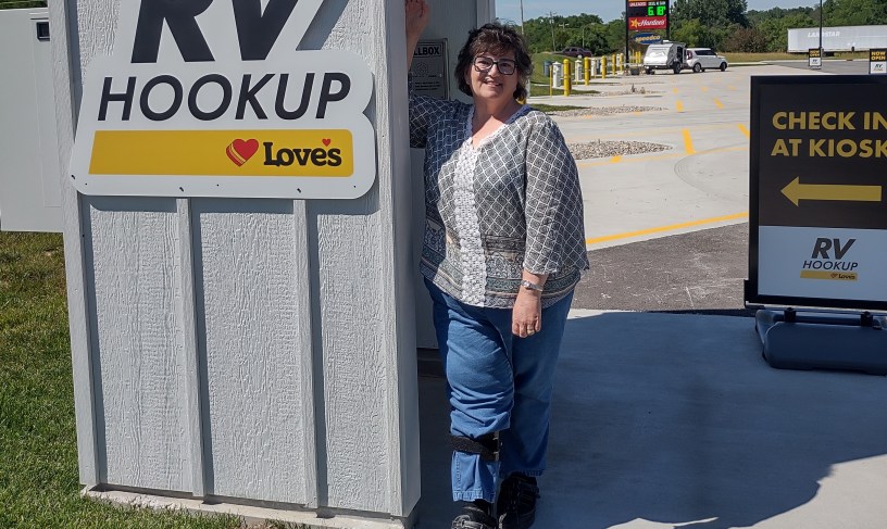 Woman standing next to a check in kiosk at s Loves RV park